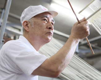 写真：手延べの様子 ホセをもつ男性